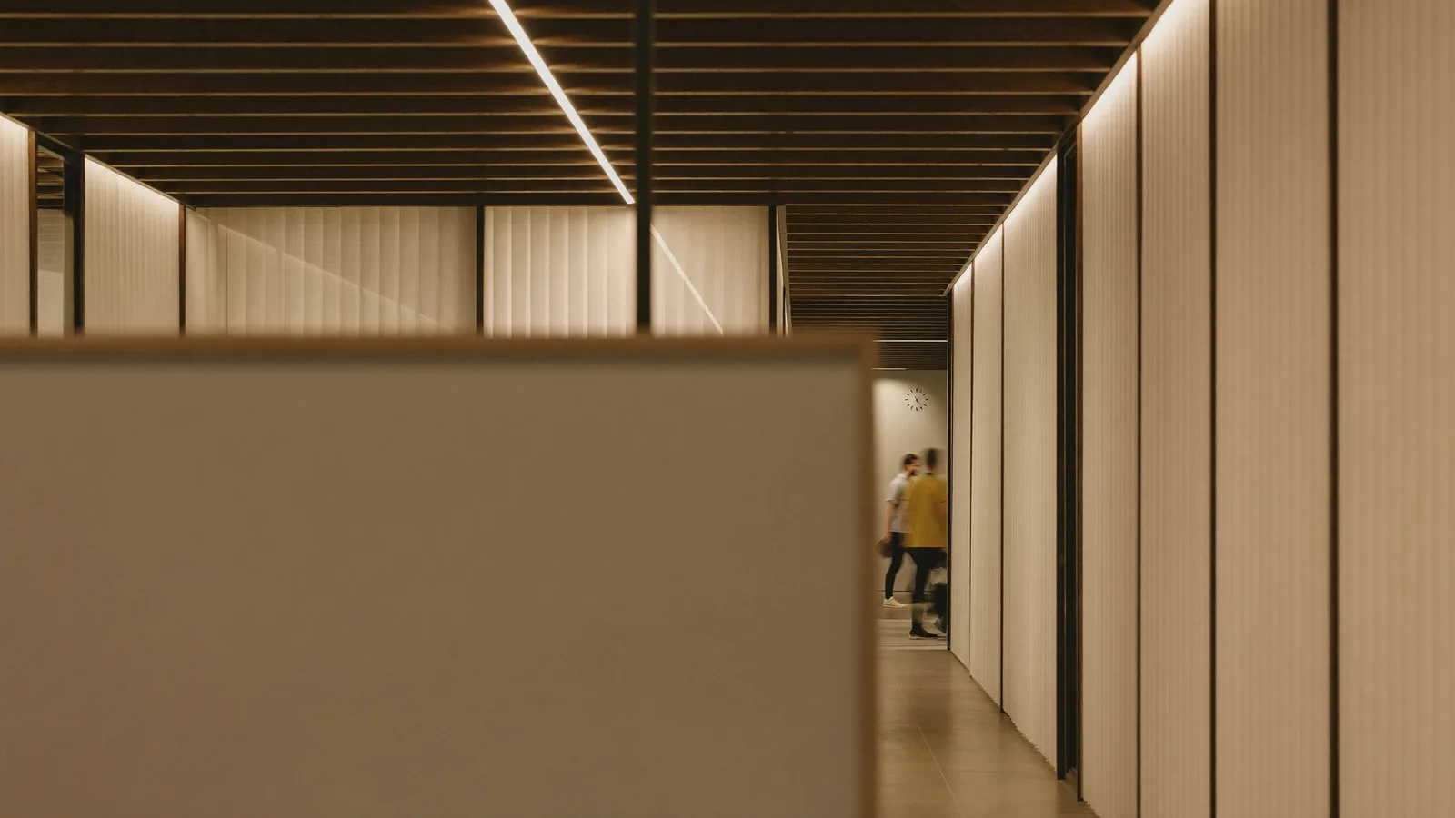 A busy recruitment office, people walking between meeting rooms, motion-blurred.